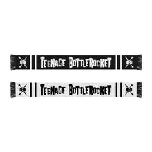 Load image into Gallery viewer, image of the front and back of a custom knit scarf on a white background. front of the scarf is on the top and is black with white text that says teenage bottlerocket. each end by the fringe has a skull. the back of the scarf is on the bottom of the image and is white with black text that says teenage bottle rocket and has black skulls by each fringed edge
