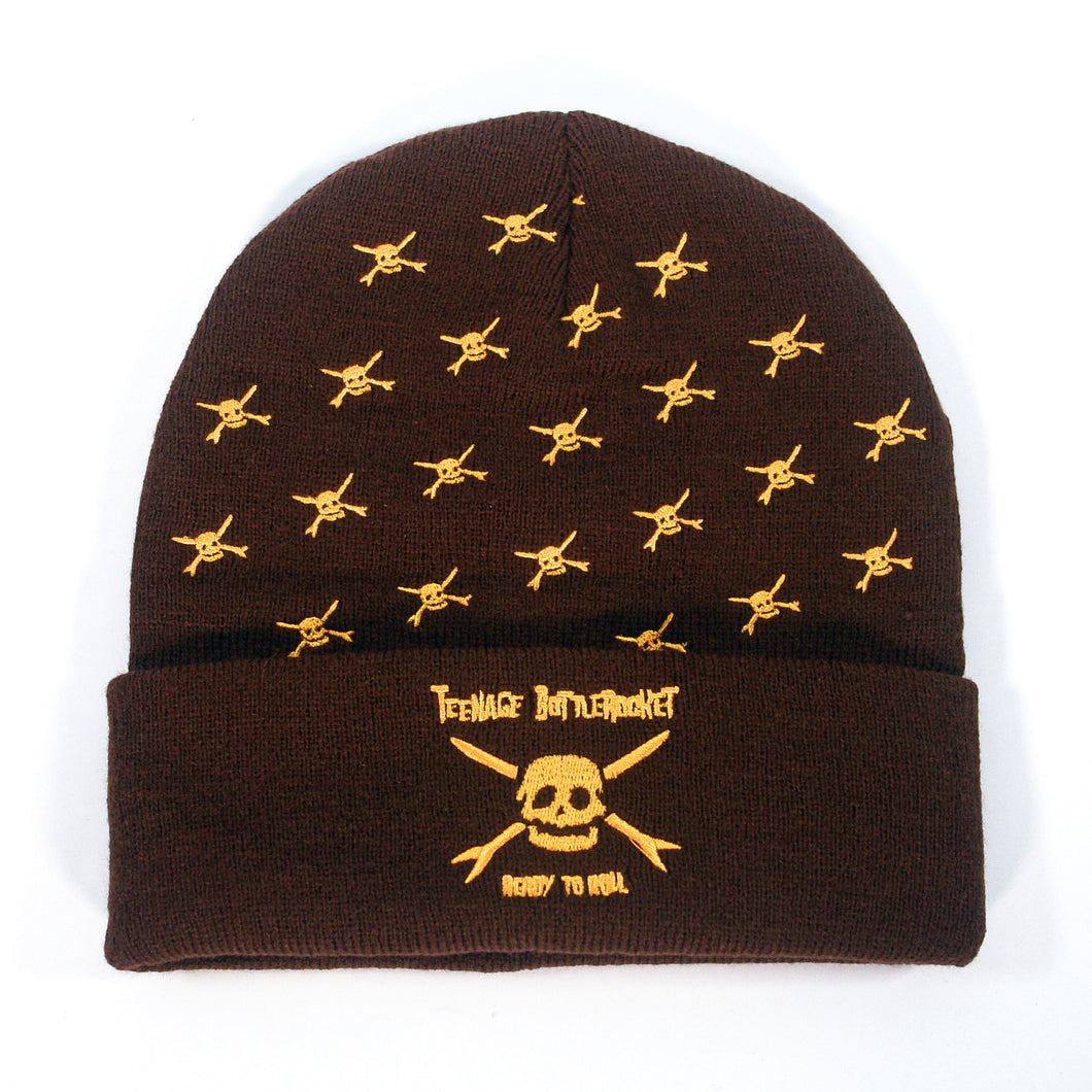 The Teenage Bottlerocket brown beanie features yellow skull and crossbones, “Teenage Bottlerocket Ready to Roll” above a large skull on the cuff—a must-have for fans.