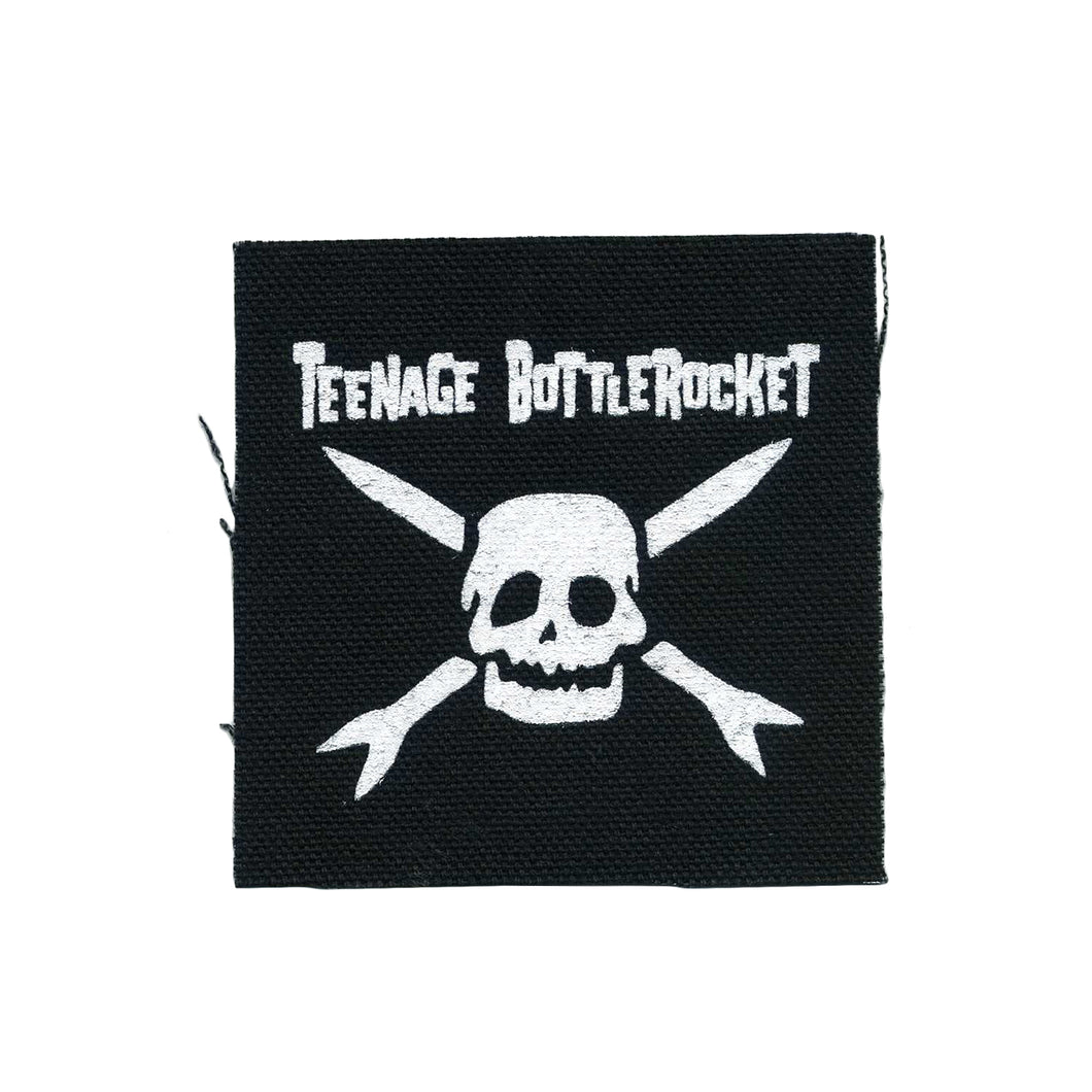 Image of a black patch against a white background. The patch says teenage bottlerocket in white text and below that is the teenage bottlerocket logo of a skull with cross arrows, also in white.