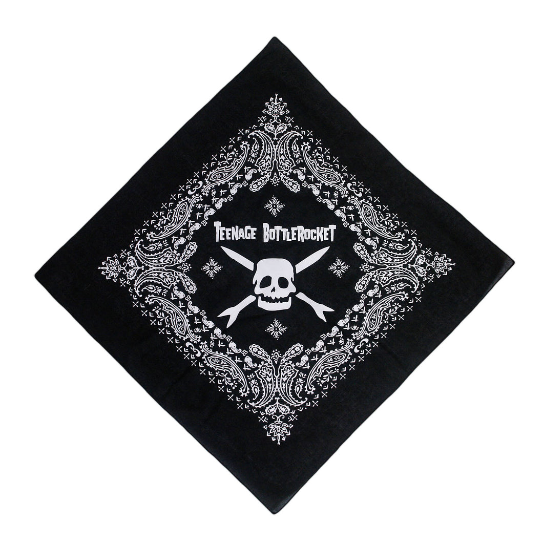 Image of a black bandana against a white background. The bandana says teenage bottlerocket in the center of it in white, and below that is their logo of a white skull head with cross arrows. Surrounding this image is a paisley pattern in white.