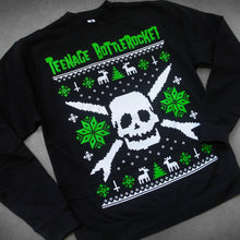 Load image into Gallery viewer, close up, angled image of a black crewneck sweatshirt laid flat on a concrete floor. crewneck has a skull in the center with snow flakes, reindeer and trees surrounding it in the style of a Christmas sweater. at the top says teenage bottlerocket
